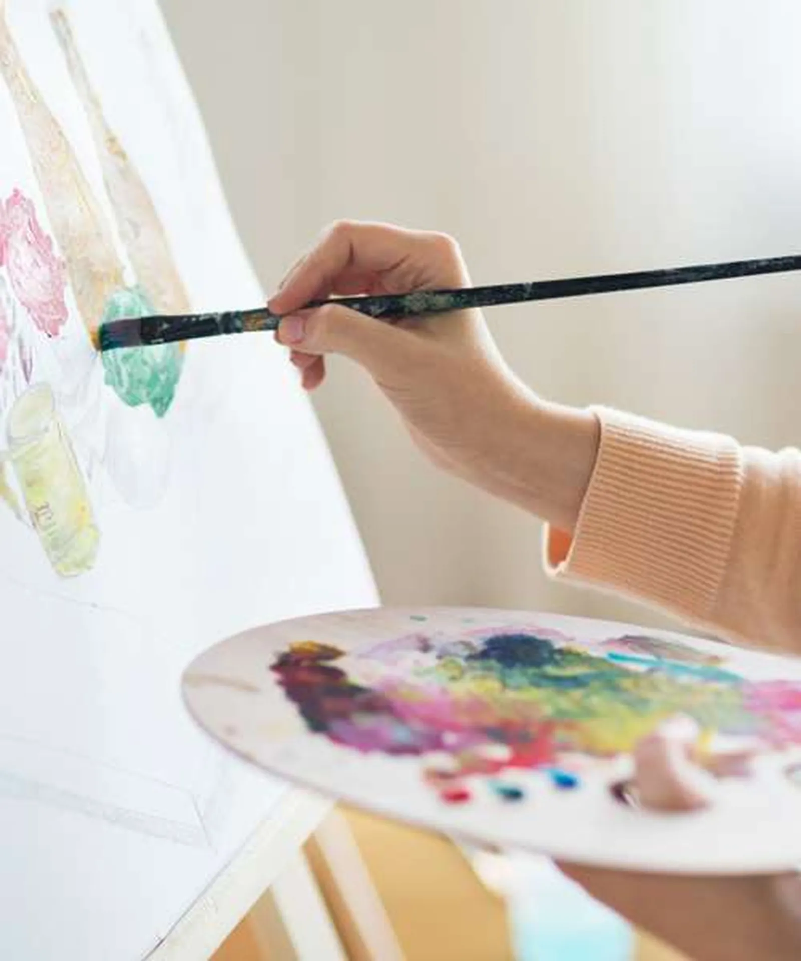 A hand painting a straw hat